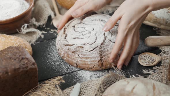 Bread Background - Various Types of Bread Are Served on the Table, a Woman Puts a Ready-made Loaf of