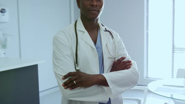 Male doctor standing with arm crossed in the hospital