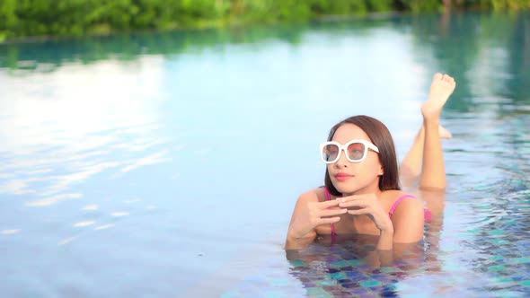 Young asian woman enjoy around outdoor swimming pool for leisure