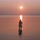 Silhouette of a woman standing in the sea staring at the sunrise - VideoHive Item for Sale