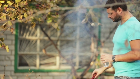 Man Cooks Meat On Barbecue