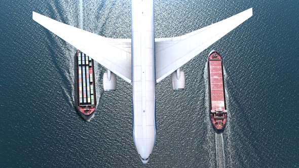Airplane flies over Cargo ships  with containers in the sea- aerial