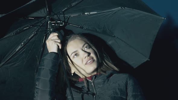 Smiling Woman Holds Umbrella Under Night Rain Slow Motion