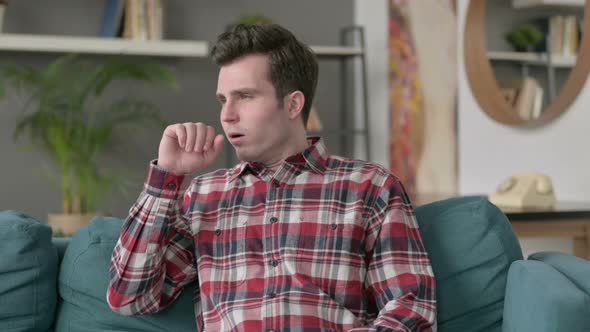 Portrait of Man Coughing While Sitting on Sofa