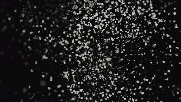 4K 30fps, White particles fly after being exploded against black background, Slow Motion