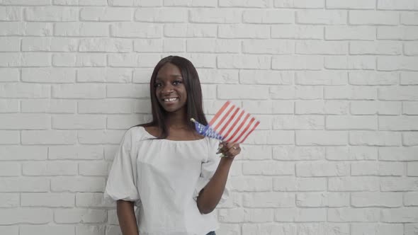 Beautiful Happy Smiling African American Young Woman Waving with an American Flag. Smiling and