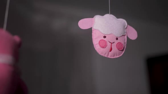 Baby Mobile with Pink Handstitched Animal and Bird Toys with Yellow Moon on White Wall Background