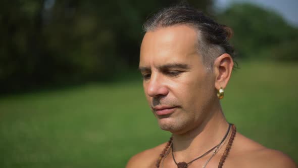 Yogi on a Background of Green Grass Looks in Front of Him.