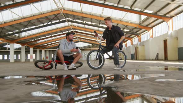 BMX riders talking in an empty warehouse