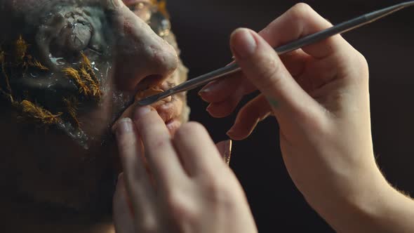 Makeup Artist Doing Man Makeup for Halloween Costume As Zombie