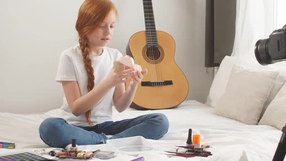 Cute Teen Girl Sits on the Bed in Front of the Camera and Records a Video for Her Channel