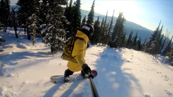 Professional snowboarder creating snow cloud riding on snowboard. Rider having fun doing tricks