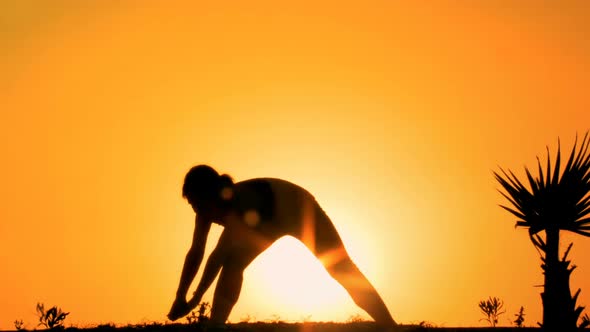 Silhouette of Flexible Female Practicing Yoga on Mountain Top at Sunset, Sport