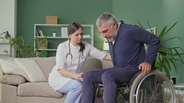 A Caring Nurse Assists a Middleaged Man in a Wheelchair at Home