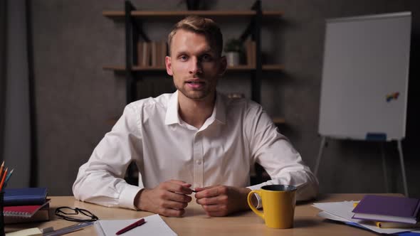 Young Man Listening To Manager's Report Via Webcam