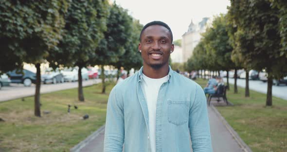 African American in Stylish Clothes which Standing in front of Camera on the City Alley