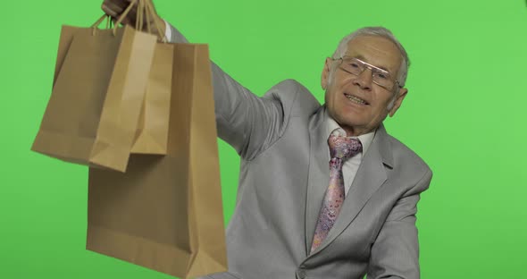 Happy Elderly Man with Shopping Bags. Old Man in Formal Wear After Shopping