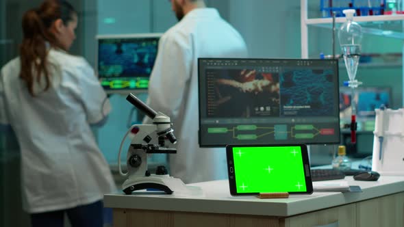 Chemists Testing Virus Evolution with Green Screen Tablet in Front on Desk