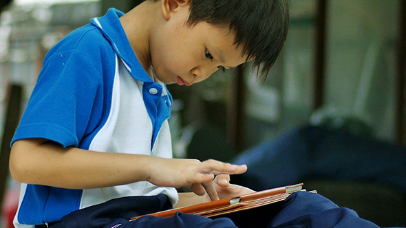 Young Boy Playing Video Game On The Tablet