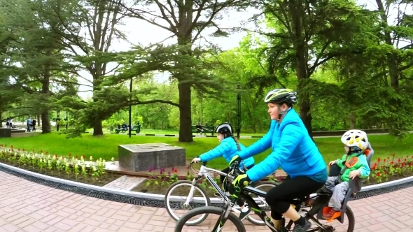 Young Mother With Two Children Riding Bicycles