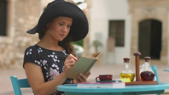 Beautiful Young Woman Reading Interesting Book, Marking Favorite Places With Pen