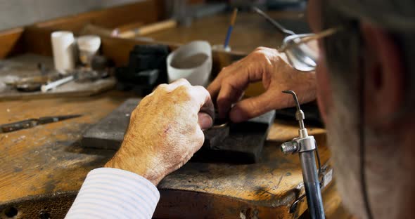 Goldsmith manufacturing jewellery in workshop