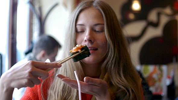 Portrait Of A Young Woman Eating Sushi