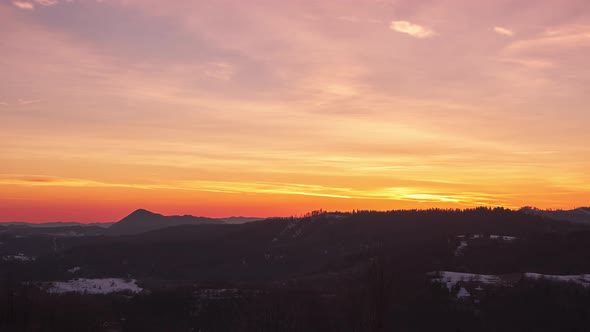 Pastel Sky with Slow Moving Clouds at Dusk Over Forest Landscape in Spring