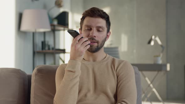 Young man recording an audio message on the phone