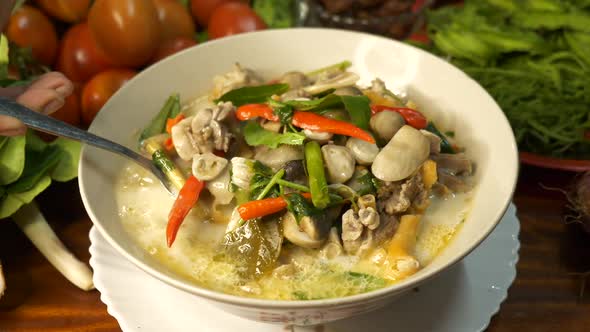 Tasting delicious traditional soup of Thailand named Tom Kha Kai