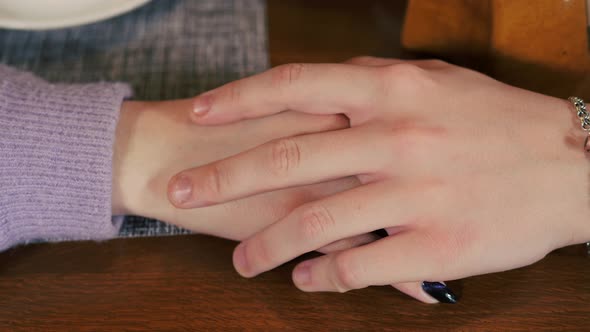 Young man's hand falls on the girl's hand.