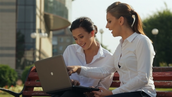 Two Girls Working On Laptop On The Bench