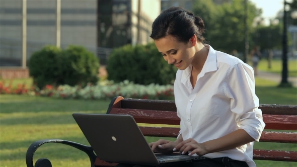 Cheerful Girl With Laptop On The Bench
