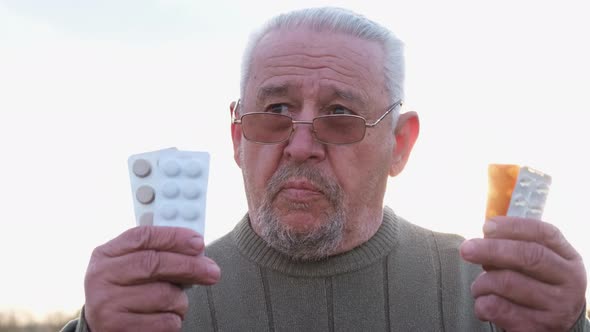 Gray Sick Grandfather with Pills in His Hands