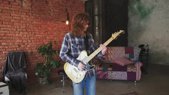 Portrait of Young Man Musician with Long Red Hair Playing Electric Guitar at Home Slow Motion