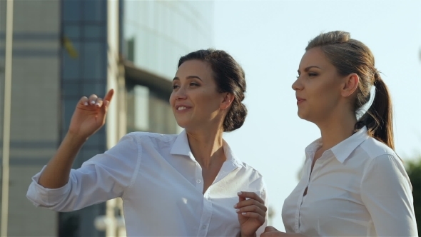 Two Cheerful Girls Having Conversation Outdoors