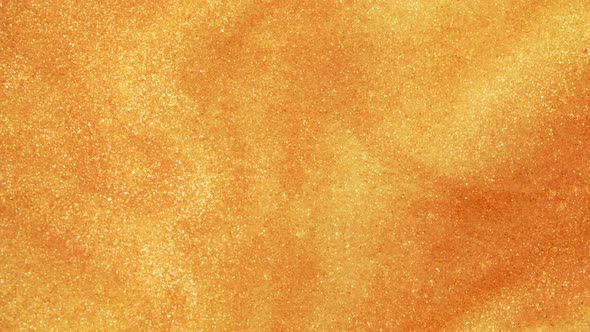 Colorful Golden Sand Organically Moves in Colorful Liquid in Macro
