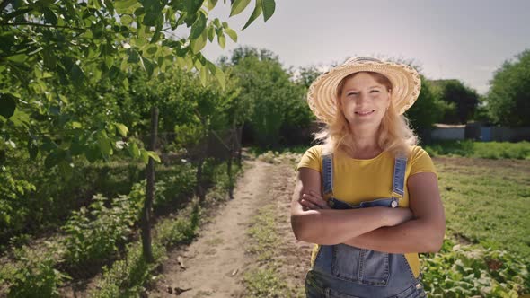 Young woman farmer stands on the plantation. Small family business.