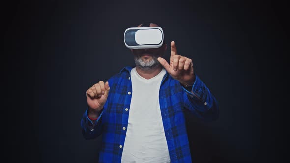 Mature Man Using VR Headset for Virtual Reality in Studio