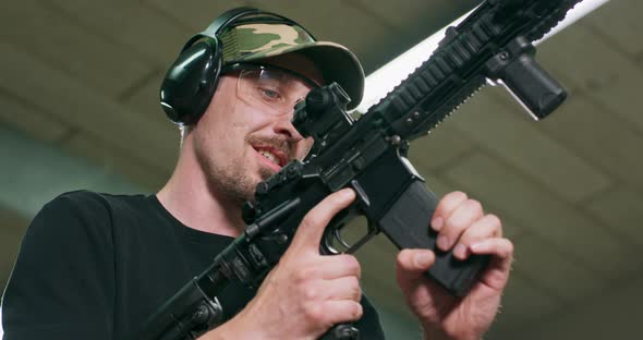 A Man Disarms the Gun By Removing the Magazine and Emptying the Chamber