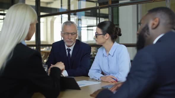 Male and Female Colleagues Listening Presentation in Meeting Room, Negotiation