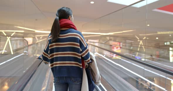 Woman take escalator at shopping center