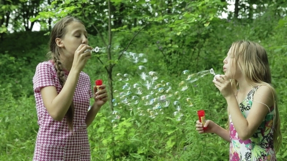 Young Girls Blowing Soap Bubbles Outdoor