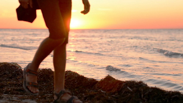 A Man Walking on the Beach at Sunset