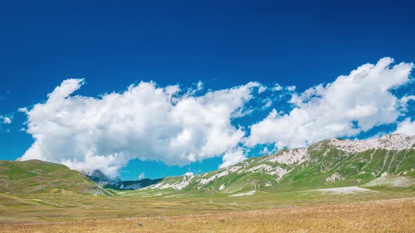 Time lapse: clouds moving in blue sky, sunny day on the mountains, view point over rocky mountain pe