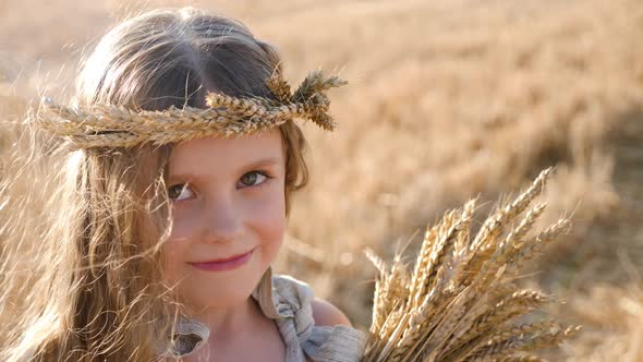 Serious Sad Girl a Child Stands on a Wheat Mown Field