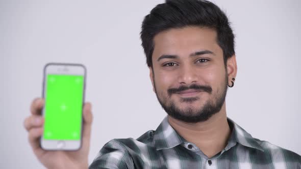 Young Happy Bearded Indian Man Smiling While Showing Phone