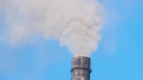 Closeup of Thermal Power Plant High Pipes with Black Smoke Moving Upwards Polluting Atmosphere