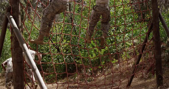 Military troops climbing a net during obstacle course 4k