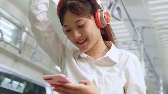 Young Woman Using Mobile Phone on Public Train